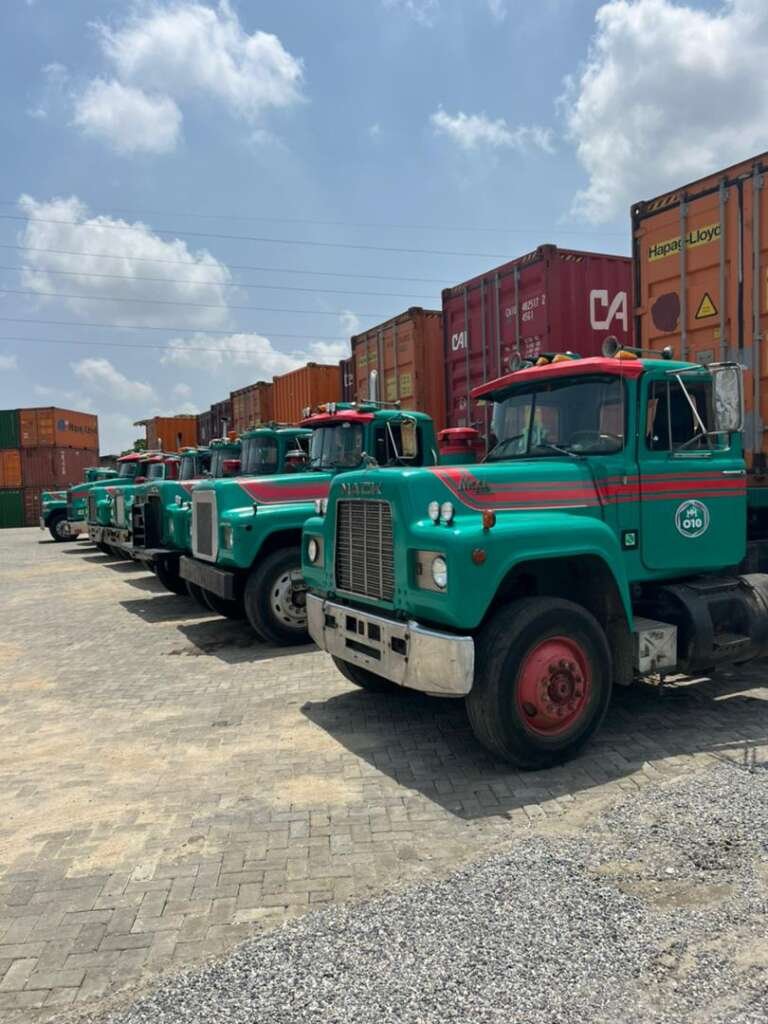 Hezegovin truck fleet lined up beside stacked containers at the Lagos terminal